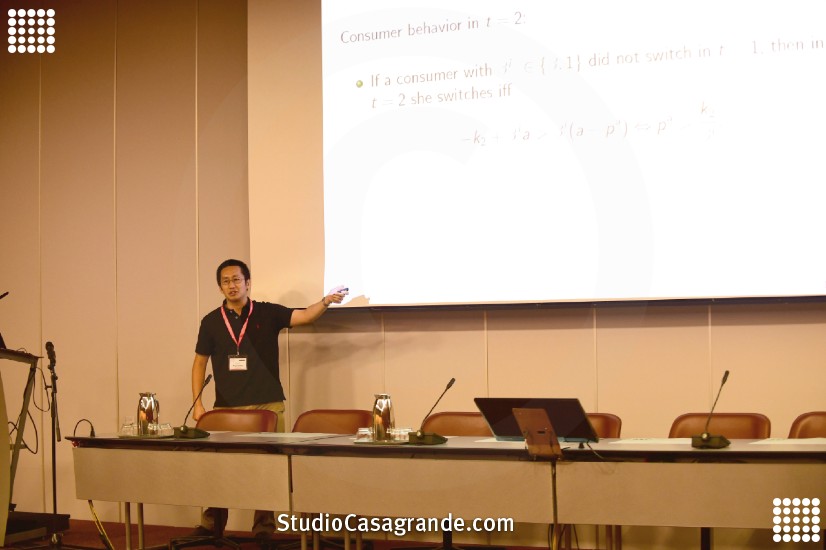 ヨーロッパ経済学会(於スイス・ジュネーブ、2016年)にて、消費者保護政策に関連する研究報告を行っている写真。