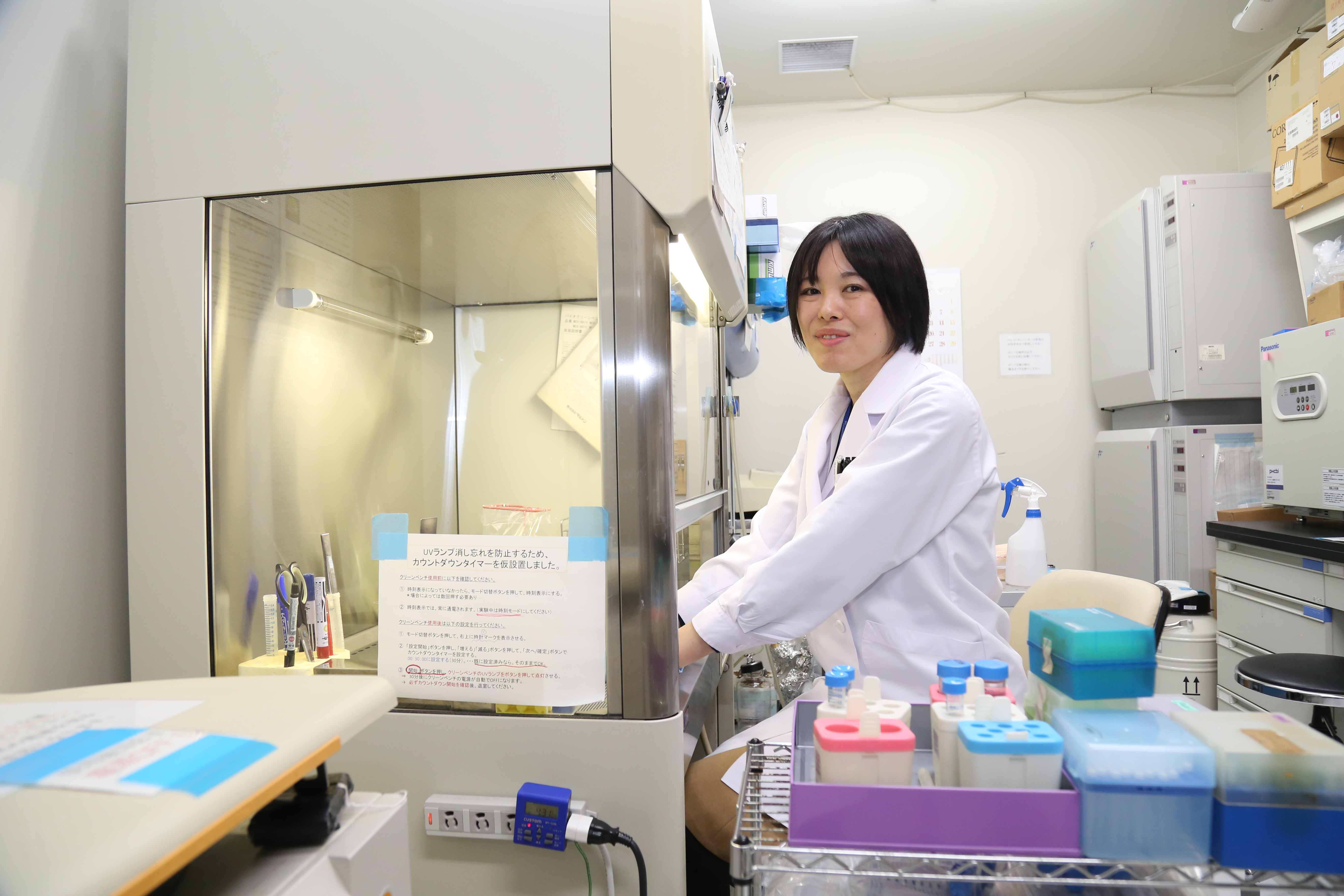 培養室で細胞培養の無菌操作を行っているところ
