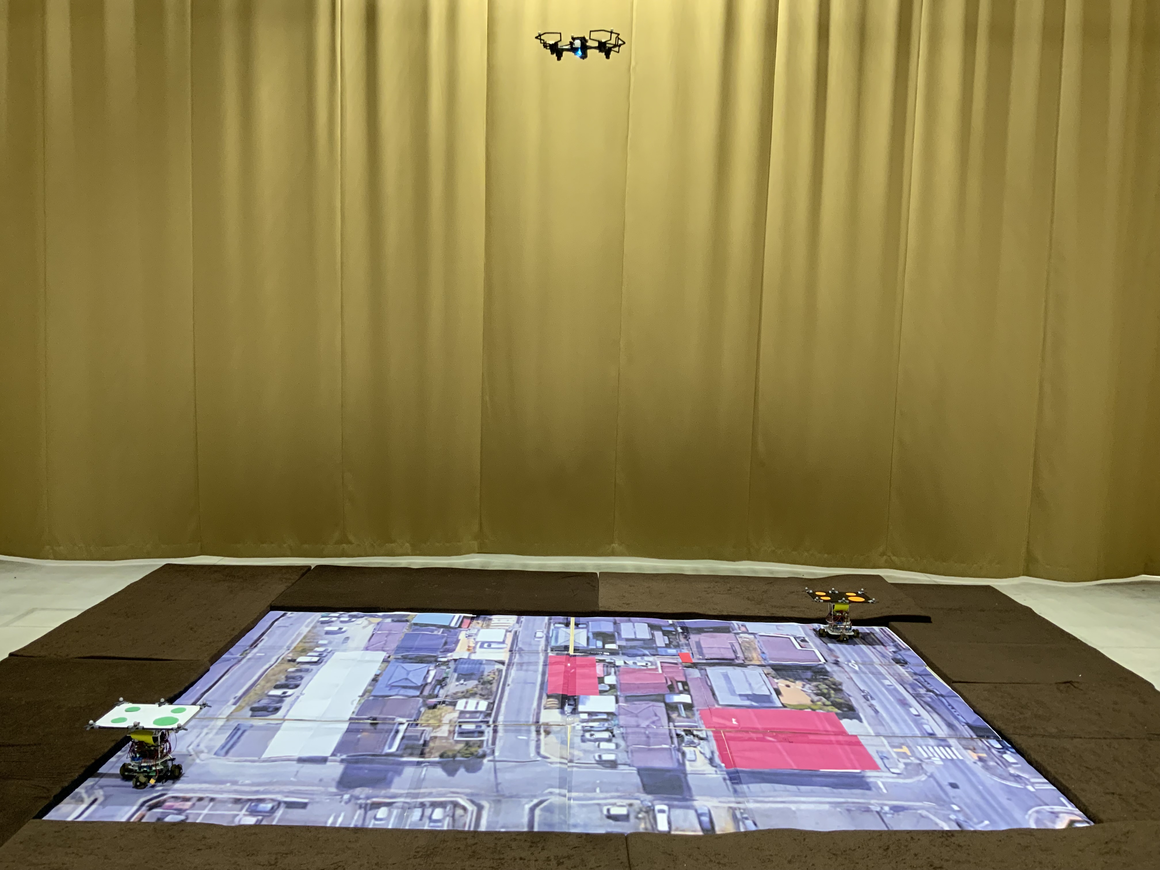 ドローンのカメラ情報を元に、2台の地上機が道路の上を走行し、目的地へ向かうように制御します。同時に、ドローンも自身のカメラ情報を用いて、位置と姿勢の両方に対して制御しています。