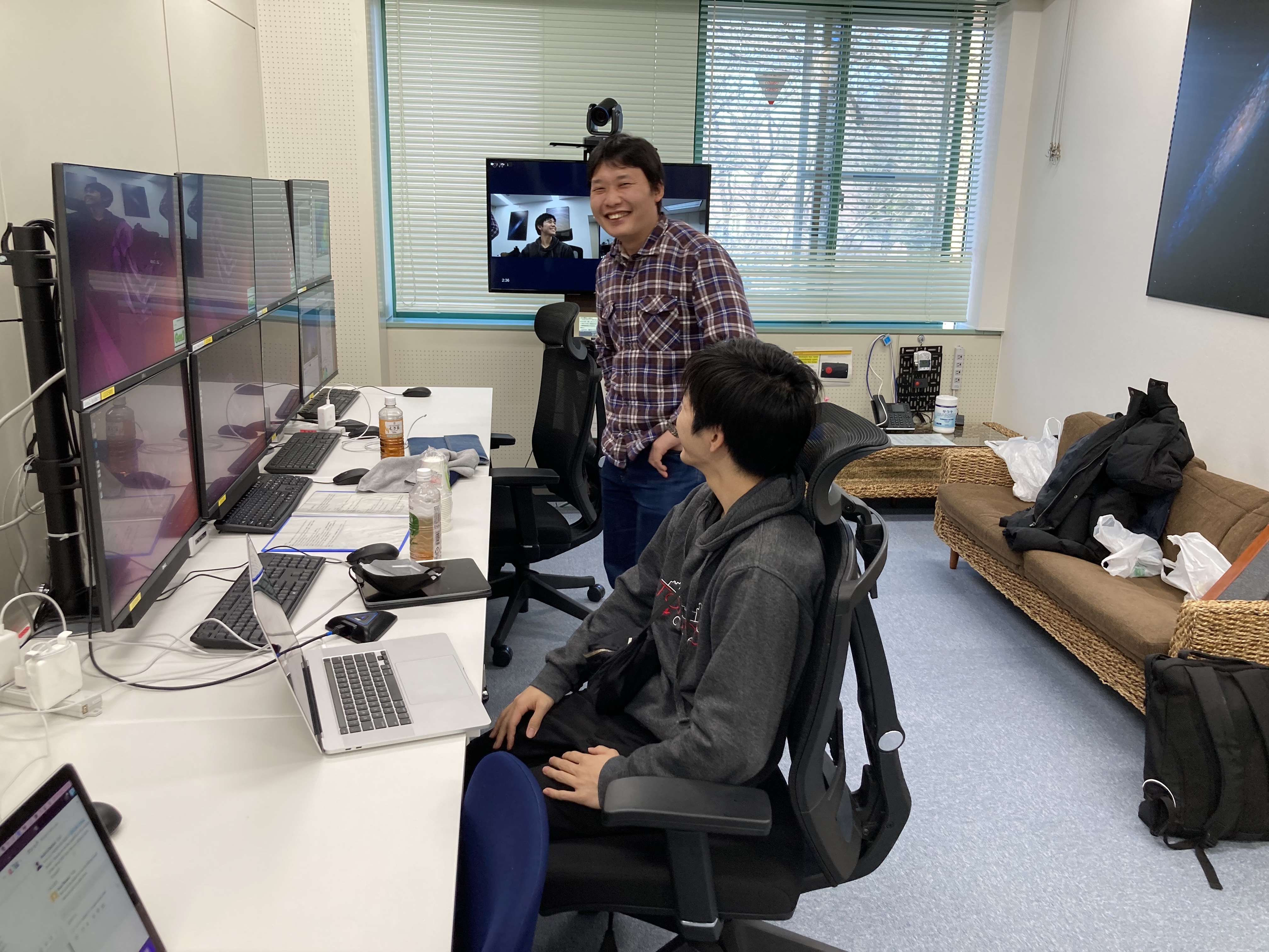 すばる望遠鏡の観測準備のようす。手前は大学院生 (当時)、奥は共同研究者の博士研究員。最近はすばる望遠鏡のあるハワイまで、国立天文台の本部三鷹キャンパスのリモート観測ルームから観測も行うことができるようになっており、ハワイにあるすばる望遠鏡の観測開始時点では日本はまだ昼間であることがわかる。