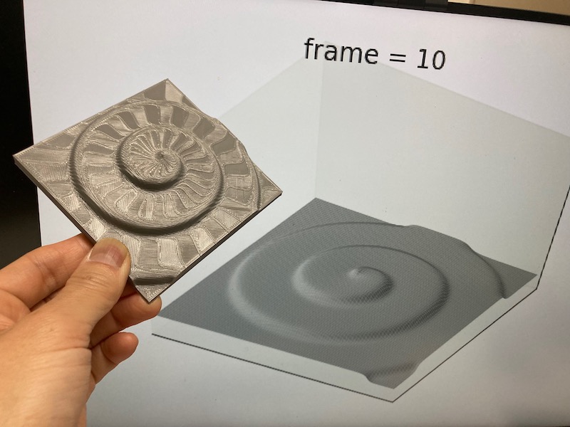結晶表面におけるらせん成長の数値計算結果(奥)と、それを3Dプリンタで「印刷」した模型(手前)