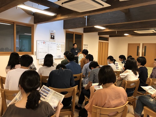 私が担当している行政学演習(ゼミナール）では、国、地方を問わず行政や政策に関する様々な課題を発見し、問題解決のための道筋を考える方法を学びます。新型コロナウィルスの感染拡大が起こる前の2019年度までは、毎年夏にゼミ合宿を兼ねて地方を訪問していました。2019年は福島県 相馬市を訪れ、東日本大震災からの復興の状況を視察しました。写真は相馬井戸端長屋で説明を受けている時のものです。