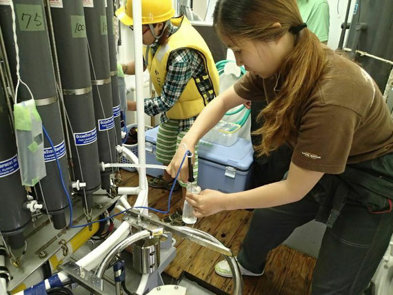実習学生が、採取した海水を不純物が混入しないように注意しながらビンに移す様子