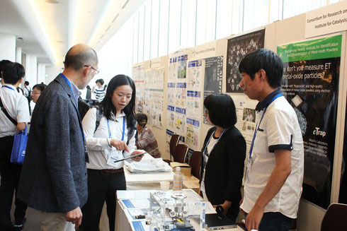 研究成果を大学院生（留学生）とともに国際会義で展示して説明中